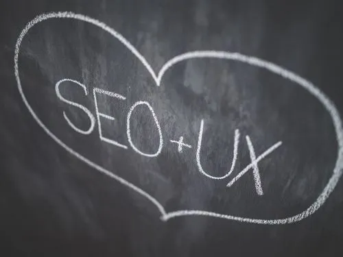 Coeur dessiné à la craie sur un tableau noir, intégrant les mots SEO et UX